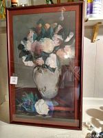 Frontal view of the framed print showing flowers in a vase under glass with reflection of light