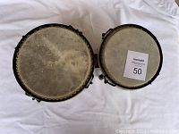 Top view of two small wooden bongo drums showing natural drum heads and wear marks.