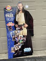 Full view of the entire life size cardboard cutout showing character Qui-Gon Jinn, layout of collectible cards scattered on blue space-themed background, promotional Lay's branding, Star Wars Episode I logo, and condition.
