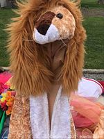 Close up of plush lion headpiece with full mane and detailed face
