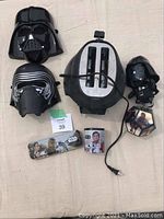 Overhead view of all items together showing toaster, three masks and Star Wars themed figure and cloth accessory