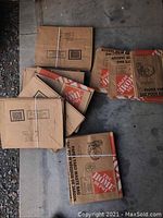 Stack of bundled flattened brown paper yard waste bags with printed graphics and text.