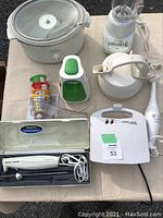 Overview image showing slow cooker, blender, Salad Express, waffle maker, electric hand mixer, immersion blender, and electric carving tool in case with serving fork and accessories.