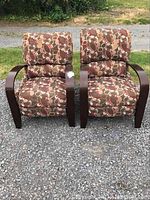 Front view of two recliners side by side showing wood arms and patterned cushions.