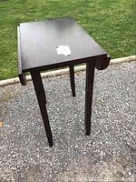 Front view of the high bar height table with fold-down extensions down, showing compact rectangular top and four legs.