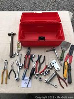 Full arrangement of red toolbox and assorted hand tools on table