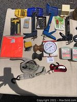 Full lot overview showing drill bit sets, pressure gauge, caulking tool, Allen keys, rubber boat rollers, cargo tie downs