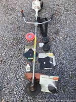 Full lot on gravel: FS 55 unit with handlebars, shaft, harness strap, spool heads, blades, line coil, oil bottle