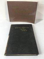 Two books shown; one is 'Greater Toronto and The Men Who Made It' with a worn black leather cover and the other titled 'Toronto' in a brown slipcase.