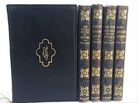 Front cover and spines view of 5 leather-bound volumes showing embossed gold detailing and cover monogram.