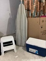 Photo showing the cooler, two-step stool, and ironing board arranged together