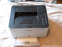 Front view of Samsung CLP 365W color laser printer showing top control panel, paper tray, and branding.