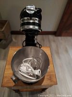 Tilt‐head stand mixer with bowl and attachments inside