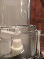 Close-up photo showing the chipped lid of the Cuisinart food processor with the white plastic safety lock piece visible which can fall out when removing the top