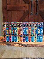 Front view of 14 VHS volumes lined up showing colorful X-MEN animated series artwork on spines with volume numbers 1 to 14.
