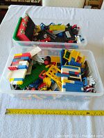 Two plastic bins filled with assorted vintage Lego pieces