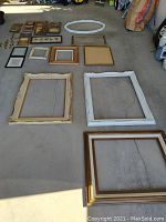 Overview of all assorted frames laid out on floor showing variety in size and materials