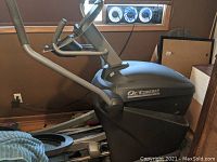 Side view of elliptical machine showing frame, moving arms, console support