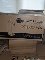 Photo of Monitor Audio Shadow 25 speaker box showing branding and series name.