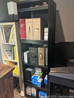 Full view of the black AV equipment rack with 10 shelves, displaying items on shelves (not included). Rack is positioned adjacent to furniture and a computer keyboard.