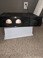 Front view showing illuminated meters and power switch on carpeted floor