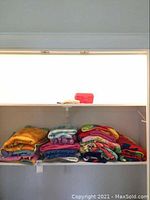 Overall shelves showing folded assorted cotton pool towels in various colors and patterns.