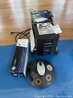 APC Smart-UPS unit with power cable, HP LaserJet cartridge box and multi-spool organizer in foreground
