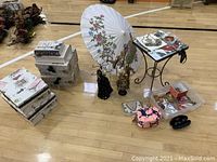 Photo showing all items in the set arranged on the floor: decorative umbrella, jewelry mannequins, purses, storage boxes, and side table with jewelry.
