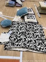 Overview of the set on gym floor showing black and white floral coverlet and pillows arranged around