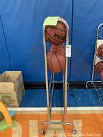 Front view of metal basketball rack with six basketballs, showing height and capacity