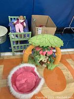 Photo showing bunk bed with dolls, floral-themed playset with monkey toy, and pink pet bed on floor