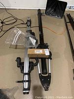 Silver aluminum crossbars and black mounting components laid out with original part box on floor