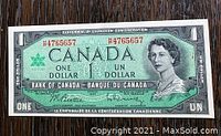 Front of 1967 Canadian Centennial One Dollar bill showing Queen Elizabeth II portrait and serial number B4765657 in red.