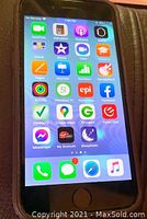 Apple iPhone 6 powered on showing the home screen with various apps, black front face visible.