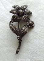 Front of the silver flower brooch with marcasite decoration.
