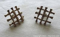 Photo of pair of sterling silver earrings in bamboo lattice design on white cloth background.