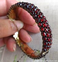 Front view of hinged bangle showing triple rows of garnets