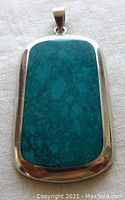 Front view of rectangular sterling silver turquoise inlay pendant showing the blue-green stone and silver frame with bail.