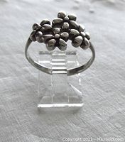 Front view of the sterling silver ring showing four prominent flower shapes on top.