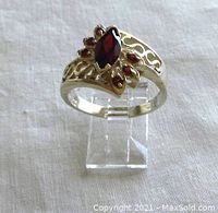 Front view of sterling silver garnet ring showcasing marquise and round garnet stones with pierced silver band design.