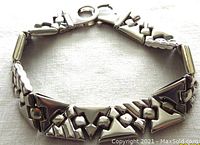 Another angle of the bracelet focusing on the lobster clasp and the serial geometric link pattern.