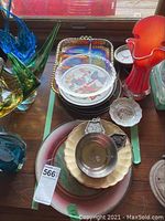 Top view photo showing the assortment including carnival glass tray, coasters, chargers, and colored glass vases