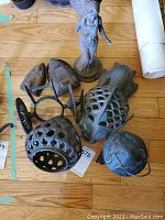 Photo showing all 8 cast iron decor pieces, including angel figure, fish, kettle, openwork vessel, and iron stand with irons.