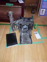 Full view of open Speed Graphic camera with accessories on floor