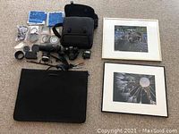 Overview of entire lot showing framed prints, camera with attached lens, carry bag, additional lenses, filters, caps, accessory items and mounting hardware