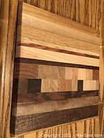 Photo of a mixed hardwood cutting board with striped and end-grain pattern detail on wood surface