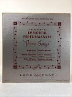 Front cover of the vinyl LP 'A Treasury of Immortal Performances Theme Songs' by RCA Victor. Shows album title, artist lineup, and decorative music notes border on silver background.