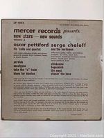 Back side of the record sleeve showing detailed printed track and artist information including Oscar Pettiford, Serge Chaloff, and others. Text is black on off-white cardboard.