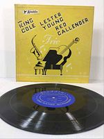 Front cover of the album with yellow background, black text and images representing the trio of musicians.