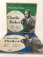 Two Charlie Parker vinyl LP records with original album sleeves, Volume 1 with green sleeve and Volume 2 with blue sleeve, both showing wear.